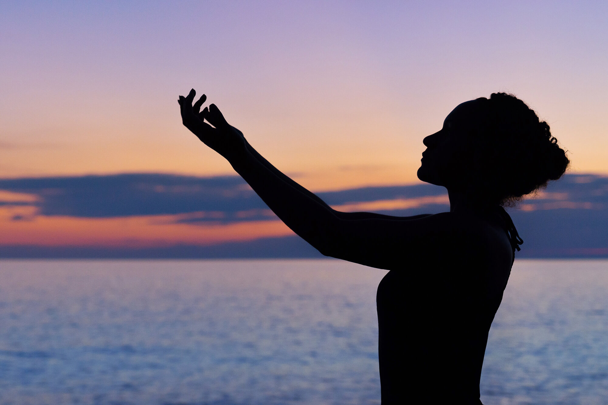 woman meditating under blue sky